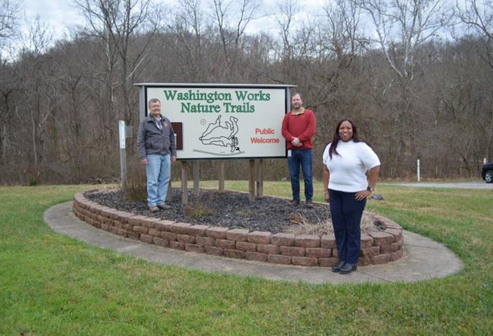 Dave Johnson, Jason Sanders, and Nicole Newell standing at Washington Works Nature Trail Sign