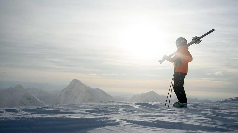 skier standing at the top of a snowy mountain