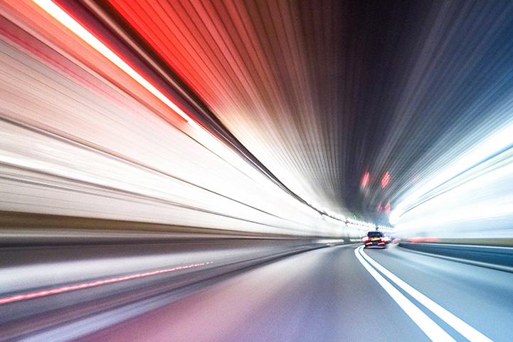 car driving at night with light blurs on either side