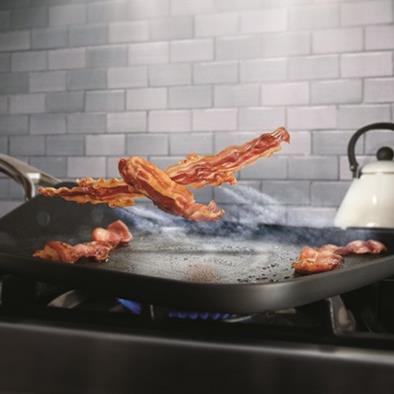 stove top pan with flying bacon as airplane