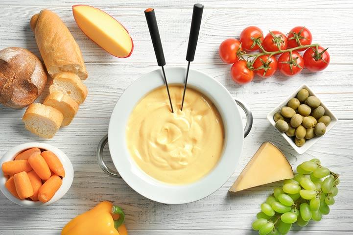Cheese fondue bowl with various foods fit for fondue