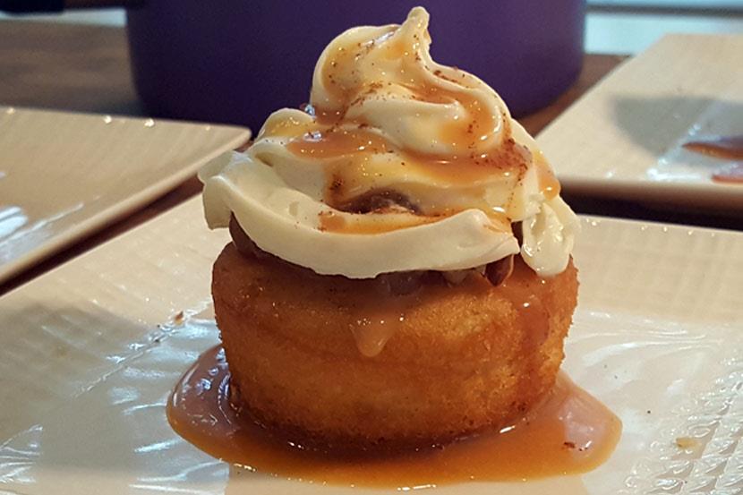 An image of a spiced apple caramel cupcake on a dessert plate.
