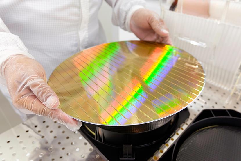 engineer holding silicon wafer in cleanroom