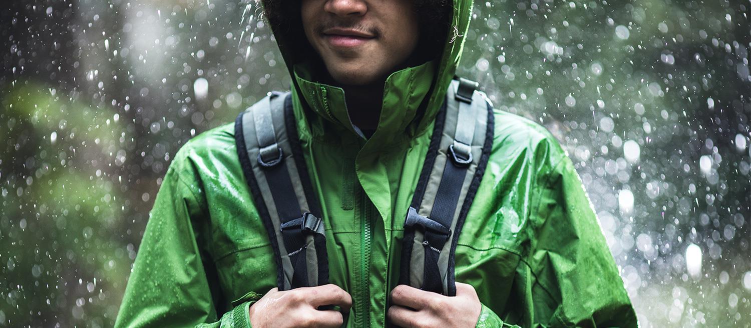 Person wearing a jacket and backpack in the rain